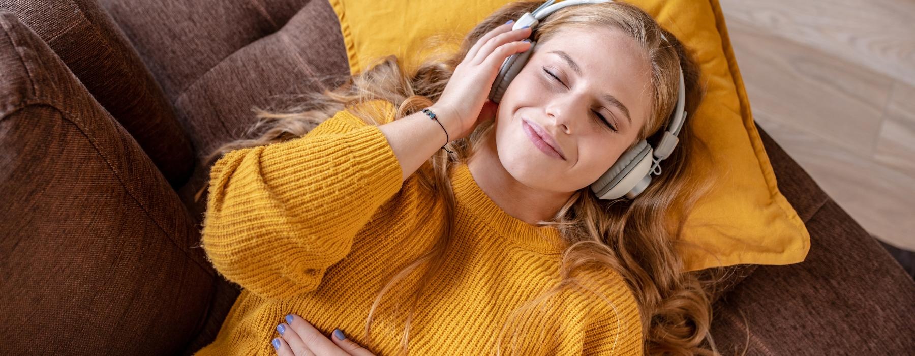 a person wearing headphones laying on the couch
