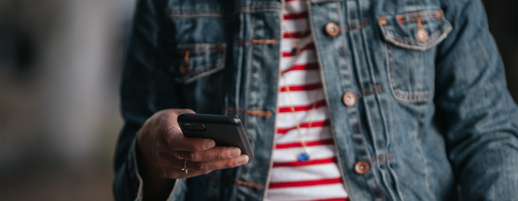 A person looks down at their phone